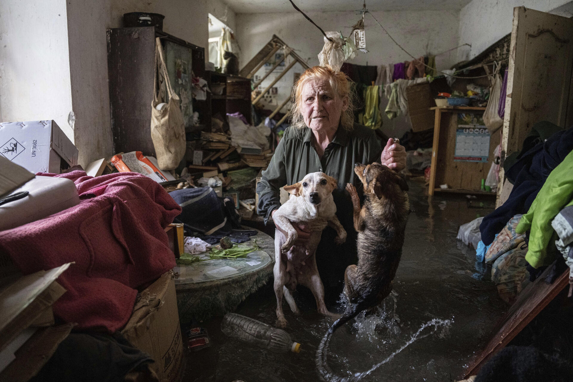 Tetiana y sus dos perros Tsatsa y Chunya, en su casa inundada en Kherson, 6 de junio de 2023. 