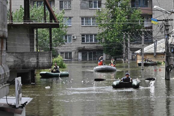Des volontaires évacuent des habitants dans un quartier inondé de Kherson, le 8 juin 2023.