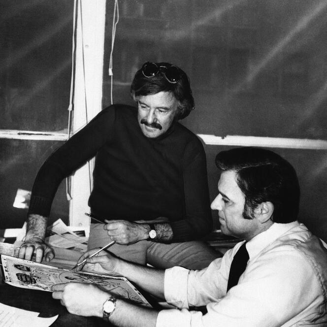 Stan Lee (con suéter oscuro) y John Romita Sr., entonces director de arte, en las oficinas de Marvel Comics en Nueva York, 1975.