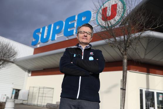 Dominique Schelcher, director de la empresa Système U, aquí frente al cartel de una de sus tiendas, en Fessenheim (Alsacia), el 25 de febrero de 2022.