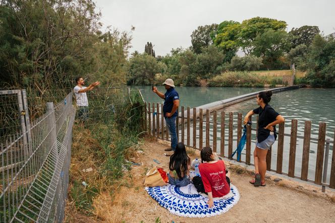 Rotem Shapiro (izquierda), un activista que lucha por el acceso público al río, es filmado por un guardia de seguridad después de escalar una valla que separa la playa pública de las costas pertenecientes al kibutz Nir David, en el norte de Israel, el 8 de junio de 2023. 