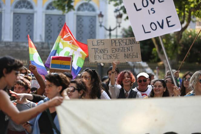 Une pancarte sur laquelle on peut lire « Les personnes trans existent en Corse aussi » est brandi, lors de la marche, à Bastia , le 17 juin 2023. 