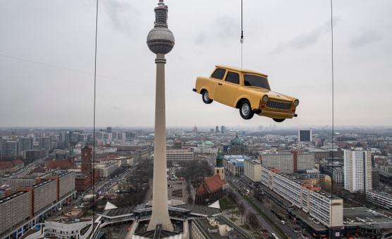 Un modelo gigante del icónico automóvil Trabant de Alemania Oriental cuelga sobre un horizonte de Berlín para una campaña publicitaria en un parque de diversiones el 3 de marzo de 2020.