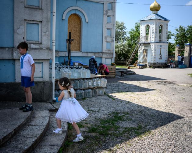 Los niños jugaron al final de la misa frente a la Iglesia Ortodoxa de la Natividad de la Virgen María en Kherson, Ucrania, el 18 de junio de 2023.