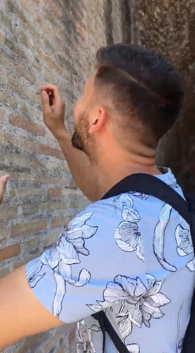 A tourist holding keys carves on the wall of the Colosseum in Rome, Italy June 23, 2023 in this picture obtained from social media. Courtesy of Ryan Lutz/via REUTERS  THIS IMAGE HAS BEEN SUPPLIED BY A THIRD PARTY. MANDATORY CREDIT. NO RESALES. NO ARCHIVES.