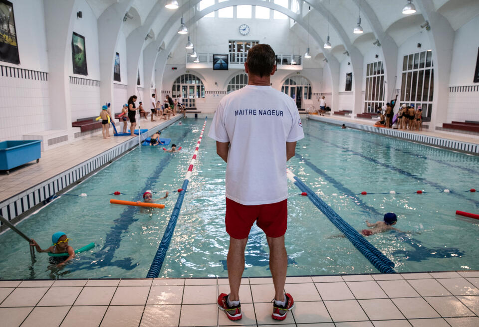 A lifeguard coaches children, on June 20, 2019, at the Butte aux Cailles swimming pool, in the 13th district of Paris. The government, the world of sports and firefighters launched the "#VigilanceNoyade" campaign on June 20 to stop the sharp rise in drowning in recent years at the beginning of the summer, during which these accidents killed last year more than 400 people in France. (Photo by Thomas SAMSON / AFP)