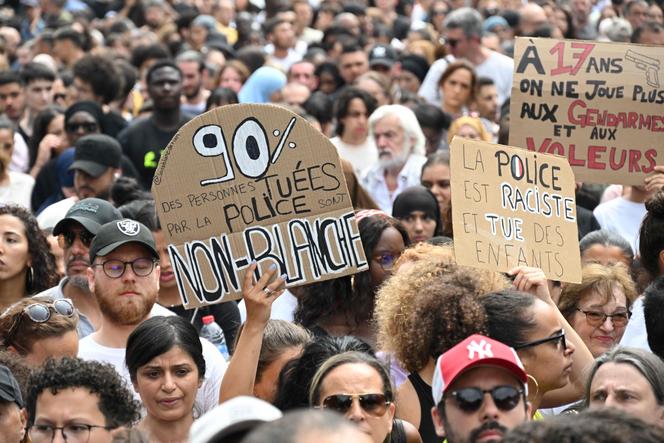 Attendees hold placards reading (from L to R)