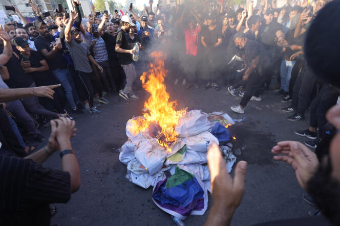 Los partidarios del líder musulmán chiíta Moqtada Al-Sadr queman una bandera del arcoíris durante una protesta frente a la embajada sueca en Bagdad, Irak, el viernes 30 de junio de 2023.