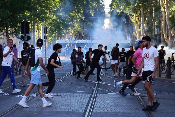 Des hommes se dispersent face aux grenades lacrymogènes lancées lors d’affrontements avec les forces de l’ordre à Marseille, le 1er juillet 2023.