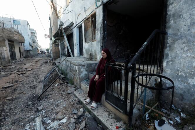 Une Palestinienne est assise sur les marches de sa maison dévastée par le raid israélien des 3 et 4 juillet 2023 sur le camp de Jénine, en Cisjordianie occupée. Le 5 juillet 2023, après le retrait des troupes israéliennes.