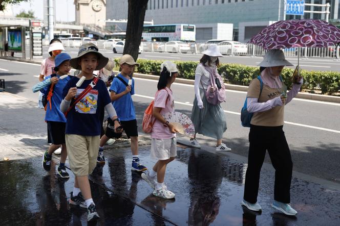 Des enfants mangent une glace, en juillet 2025, à Pékin.
