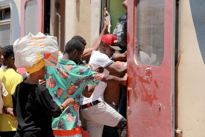 African migrants board a train on July 5, 2023, as they flee to Tunis amid unrest in Sfax following the July 3 knife attack on a Tunisian man during an altercation with migrants.