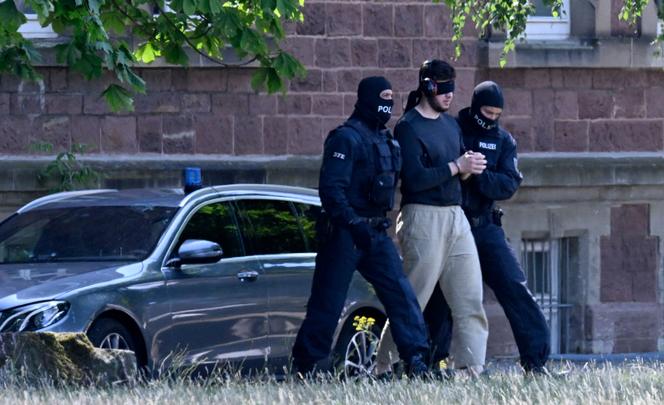 Policías enmascarados escoltan a uno de los siete hombres sospechosos de haber participado en la formación de una célula terrorista hasta un helicóptero, tras su comparecencia ante el Tribunal Federal de Justicia en Karlsruhe, en el sur de Alemania, el 6 de julio de 2023.