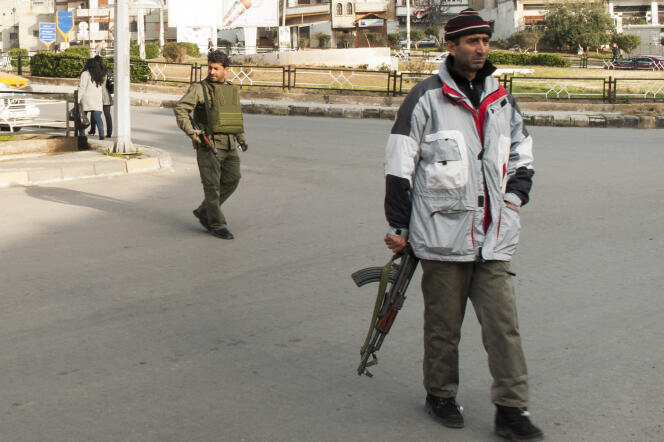 Des miliciens du régime syrien contrôlent le trafic dans le quartier de Hadara, à Homs (Syrie), pendant la guerre civile, le 11 janvier 2012. 