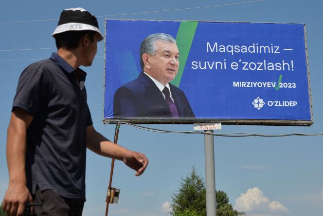 Un homme passe devant un panneau d’affichage de campagne du président sortant de l’Ouzbékistan et candidat à la présidentielle Chavkat Mirzioïev à Krasnogorsk, à environ 60 kilomètres de Tachkent, le 8 juillet 2023.