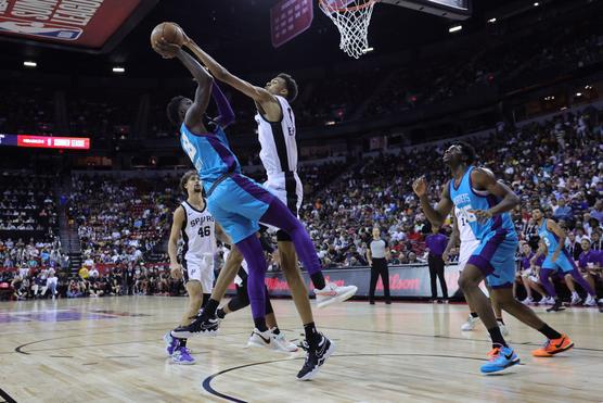 Victor Wembanyama, de camiseta blanca, realiza un contraataque al jugador de Charlotte Tre Scott durante la Liga de Verano, en Las Vegas, Nevada, el 7 de julio de 2023.
