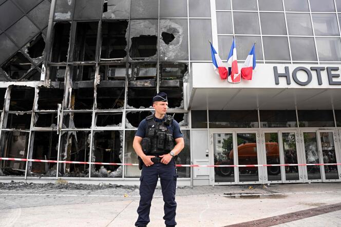 Un policier devant l’hôtel de ville de Garges-lès-Gonesse, incendié durant les émeutes urbaines qui ont suivi la mort de Nahel M., le 29 juin 2023.