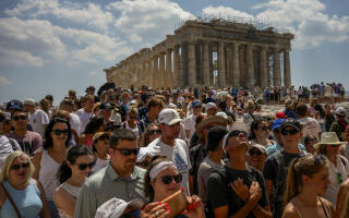 Atop the Acropolis ancient hill, tourists visit the Parthenon temple, background, in Athens, Greece, Tuesday, July 4, 2023. Crowds are packing the Colosseum, the Louvre, the Acropolis and other major attractions as tourism exceeds 2019 records in some of Europe’s most popular destinations. While European tourists helped the industry on the road to recovery last year, the upswing this summer is led largely by Americans, who are lifted by a strong dollar and in some cases pandemic savings. (AP Photo/Thanassis Stavrakis)