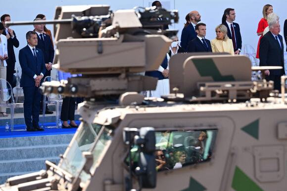 Le ministre de l’intérieur et des outre-mer français, Gérald Darmanin, le président de la République française, Emmanuel Macron, et  son épouse, Brigitte, assistent au défilé militaire du 14-Juillet sur l’avenue des Champs-Elysées, à Paris, le 14 juillet 2023.