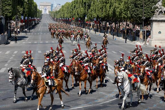Des officiers de cavalerie de la garde républicaine montent à cheval lors du défilé militaire du 14-Juillet sur l’avenue des Champs-Elysées, à Paris, le 14 juillet 2023.