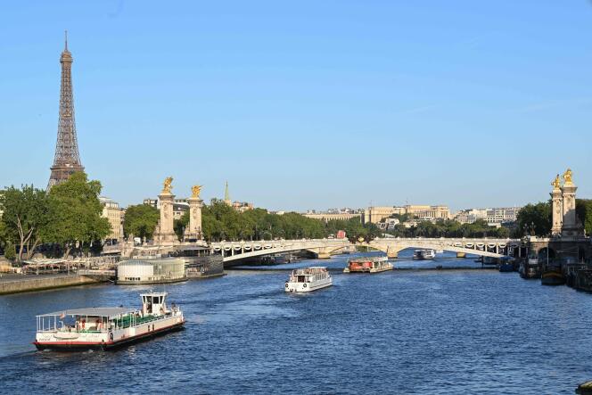 Las barcazas pasan frente a la Torre Eiffel, en el Sena, el 17 de julio de 2023, durante un desfile para probar 