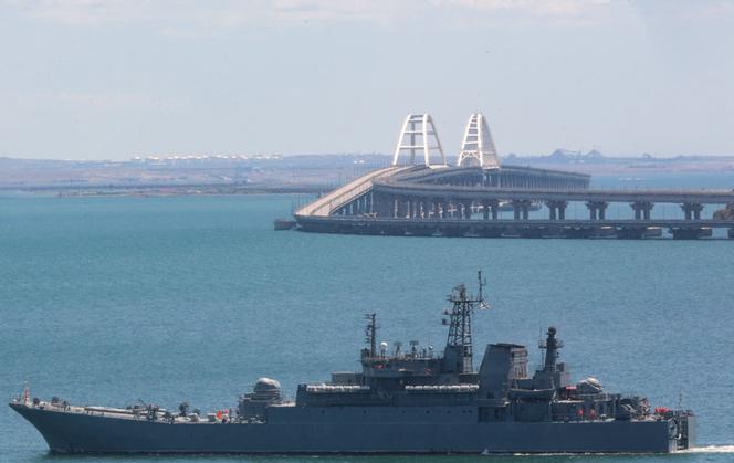 TOPSHOT - A picture taken on July 17, 2023 shows a Russian warship sailing near the Kerch bridge, linking the Russian mainland to Crimea, following an attack claimed by Ukrainian forces. Waterborne drones struck the sole bridge connecting Russia to the annexed Crimea peninsula on July 17, in a deadly attack on a vital supply route claimed by Ukraine's security services. (Photo by STRINGER / AFP)
