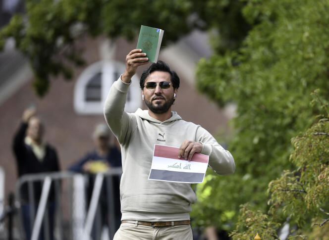 L’activiste Salwan Momika, devant l’ambassade d’Irak à Stockholm, tenant un drapeau irakien et un exemplaire du Coran, le 20 juillet 2023.