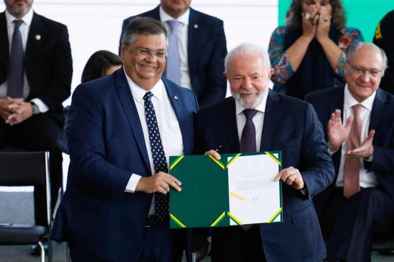 El presidente brasileño Luiz Inacio Lula da Silva (derecha) y el ministro de Justicia Flavio Dino (izquierda) después de firmar un decreto que regula el uso de armas de fuego por parte de civiles, en Brasilia, el 21 de julio de 2023.