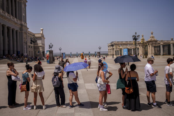 People queue to enter the Royal Palace during a hot and sunny day of summer in Madrid, Spain, Wednesday, July 19, 2023. Most of Spain is under alert for high to extreme heat with forecasts calling for peak temperatures of 43 C (109 F) in areas along the Ebro River in the northeast and on the island of Mallorca. Spain is also dealing with a prolonged drought that has increased concerns about the risk of wildfires. (AP Photo/Manu Fernandez)
