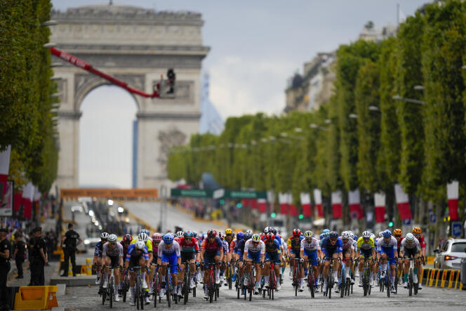 Peleton Tour de France przyspiesza na Polach Elizejskich w niedzielę, 23 lipca 2023 r.