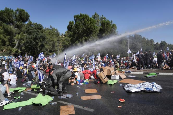 La police israélienne disperse des manifestants bloquant la route menant à la Knesset, le Parlement israélien, à Jérusalem, le lundi 24 juillet 2023. 