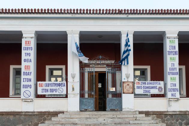 Signs against fish farms are posted on a school on the island of Poros, Greece, on July 4, 2023.