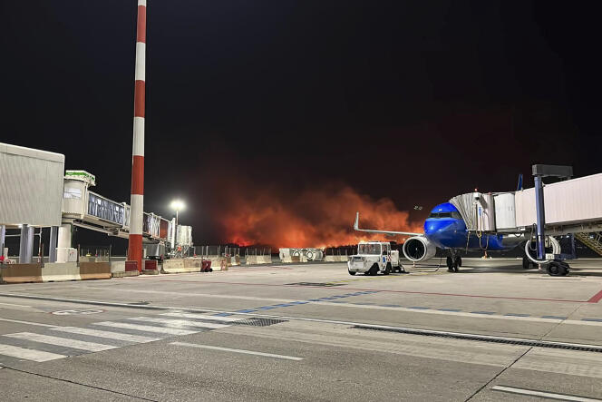 This photo provided by Palermo Airport Press Office shows plumes of fire and smoke covering the hills surrounding Palermo's airport, Sicily, Italy, late Monday night, July 24, 2023, causing its shutdown and leaving planes trapped on the tarmac. 