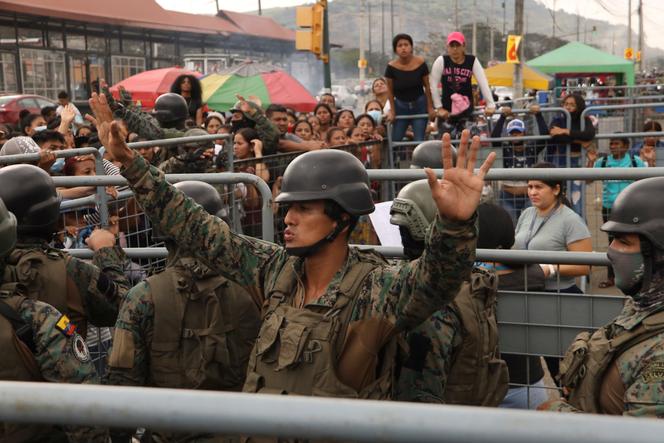 Des soldats demandent le calme autour de la prison de Litoral, à Guayaquil, en Équateur, où se sont réunis des amis et des membres de la famille de détenus, le 25 juillet 2023. 