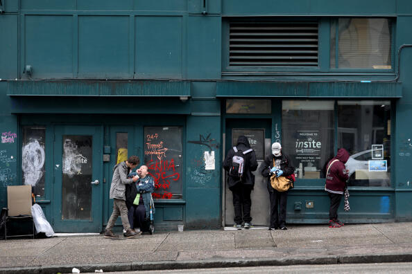 VANCOUVER, BRITISH COLUMBIA - MAY 03 : Clients wait outside of Insite, a supervised consumption site located in the Downtown Eastside (DTES) neighborhood, has injection booths where clients inject pre-obtained illicit drugs under the supervision of nurses and health care staff. Clean injection equipment such as syringes, cookers, filters, water and tourniquets are supplied. If an overdose occurs, the team, led by a nurse, are available to intervene immediately (from the Vancouver Coastal Health website), on Tuesday, May 3, 2022 in Vancouver, British Columbia. Supervised consumption sites in the DTES give addicts who use fentanyl, opioids, crystal methamphetamine and other drugs a place to use and get harm reduction supplies ; clean syringes, alcohol swabs, sterile water, tourniquets, spoons and filters. On April 14, 2016, provincial health officer Dr. Perry Kendall declared a public health emergency under the Public Health Act due to the significant rise in opioid-related overdose deaths reported in B.C. since the beginning of 2016. (Gary Coronado / Los Angeles Times via Getty Images)