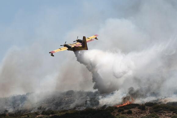 Un Canadair largue de l’eau sur un feu de forêt près de la ville de Volos, en Grèce centrale, le 27 juillet 2023.