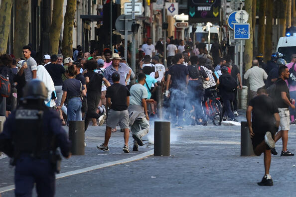 Protesters flee as tear gas is fired by police during a demonstration against police in Marseille, southern France on July 1, 2023, after a fourth consecutive night of rioting in France over the killing of a teenager by police. French police arrested 1311 people nationwide during a fourth consecutive night of rioting over the killing of a teenager by police, the interior ministry said on July 1, 2023. France had deployed 45,000 officers overnight backed by light armoured vehicles and crack police units to quell the violence over the death of 17-year-old Nahel, killed during a traffic stop in a Paris suburb on June 27, 2023. (Photo by CLEMENT MAHOUDEAU / AFP)