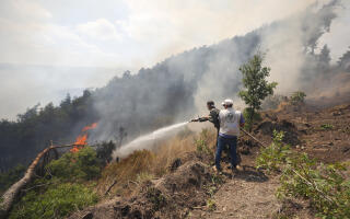 Firefighters try to stop the first fire in Latakia Governorate, western Syria, Saturday, July 29, 2023. (AP Photo/Omar Sanadiki)