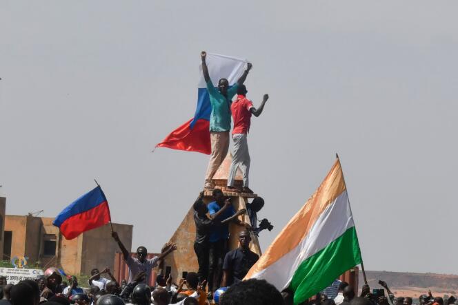 Protesters wave Nigerien and Russian flags as they gather during a rally supporting Niger's junta in Niamey, on July 30, 2023.