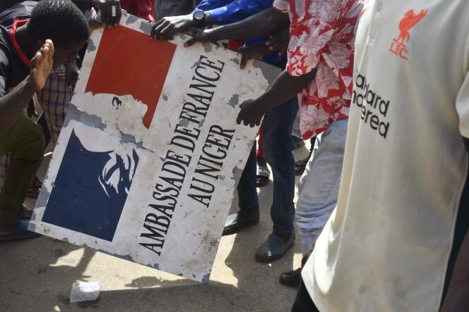Manifestantes con una placa tomada de la embajada de Francia en Níger, durante una manifestación posterior a la manifestación en apoyo de la junta de Níger, en Niamey, el 30 de julio de 2023.
