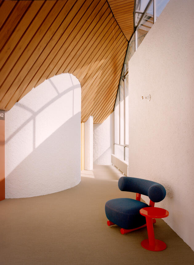 In un corridoio, poltrona e tavolino Pipe, design Sebastian Herkner per l'editore italiano di mobili Moroso.