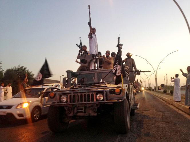 Des combattants de l’organisation Etat islamique parade à Mossoul (Irak), en juin 2014.