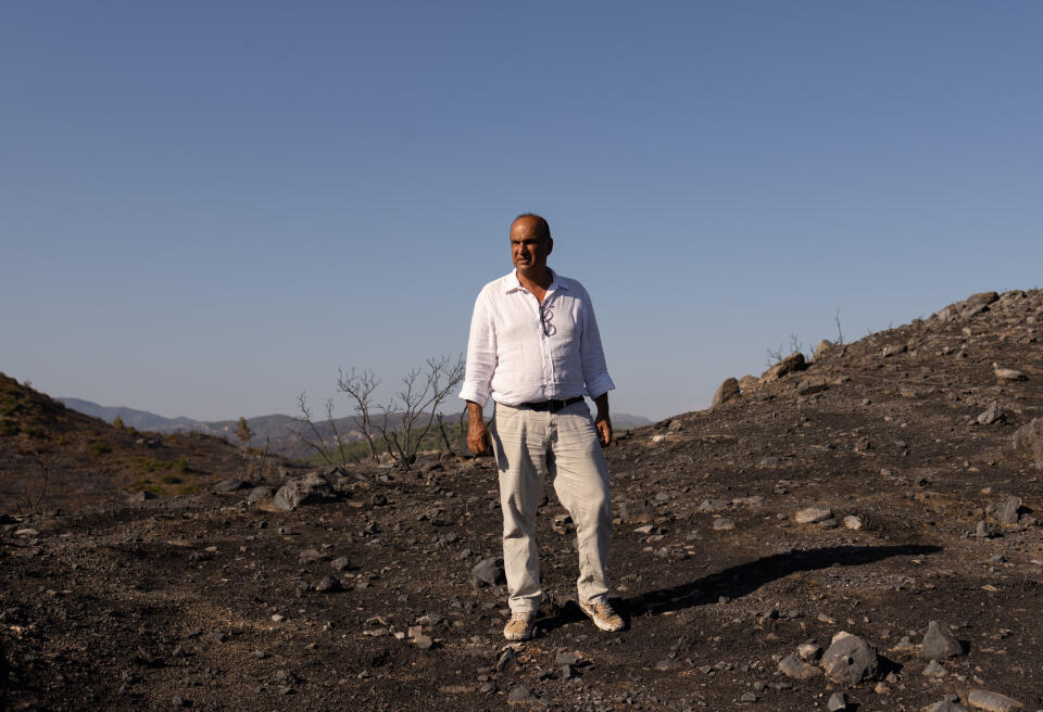 Nektarios Kalogirou, 52 is seen on a burned field following a wildfire in the island of Rhodes, Greece. 1 August 2023. Louiza Vradi for Le Monde
