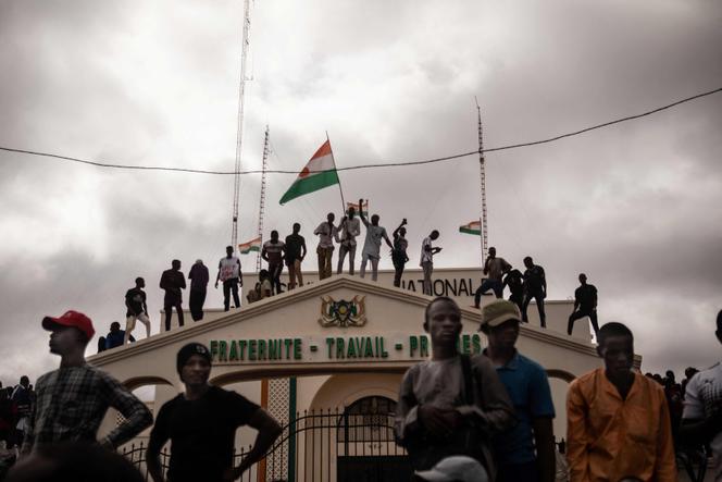  Protesters hold a Niger flag during a demonstration on independence day in Niamey on August 3, 2023. 