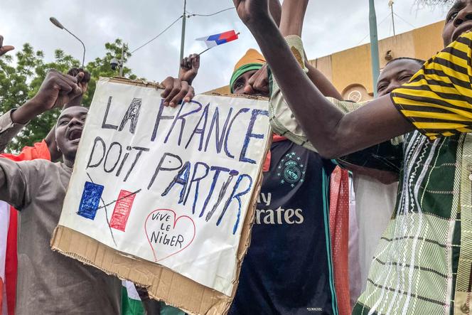 Protesters hold an anti-France placard during a demonstration on independence day in Niamey on August 3, 2023. 