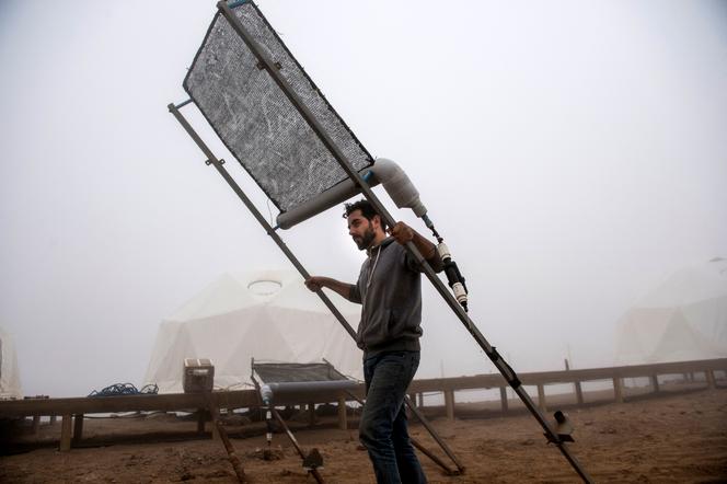 Catholic University of Chile research station coordinator Nicolas Zanetta carries part of a fog collection system in the Atacama Desert, Iquique, Chile, April 19, 2016.