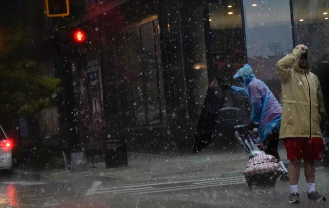 An umbrella is blown inside out as a person crosses the street during a storm in Washington, DC, on August 7, 2023.