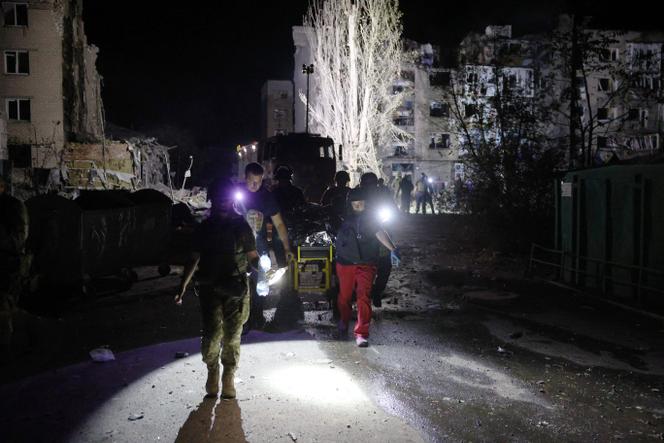 Rescuers carry a wounded person from a damaged residential building following Russian missiles strikes in Pokrovsk, Donetsk region, amid Russian invasion of Ukraine, on August 7, 2023.