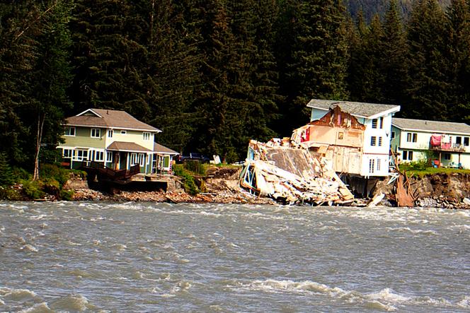 A home hangs over the edge of an eroded riverbank after part of the neighboring house fell into the Mendenhall River in Juneau, Alaska, on August 6, 2023.