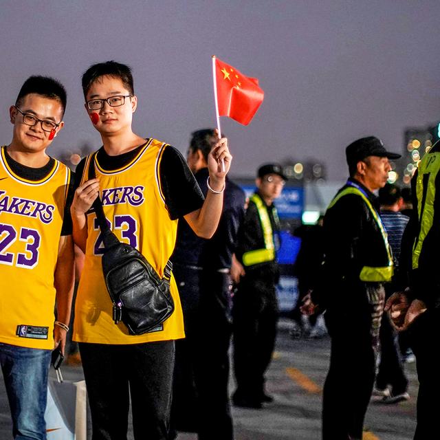 ALY SONGS/REUTERS Fans in LeBron James jerseys pose for pictures with Chinese flags near security personnel outside the Mercedes-Benz Arena before the NBA exhibition game between Brooklyn Nets and Los Angeles Lakers in Shanghai, China October 10, 2019. REUTERS/Aly Song - RC12E1B64410